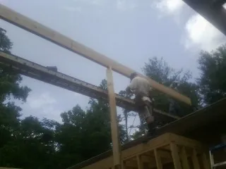 Carpenter setting a ridge beam over a new addition frame — Ice Dam Removal by Roofing Brothers in Norwell