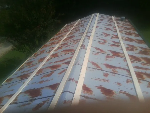 Rusted metal roof panels with new wood purlins before replacement — Storm Damage Roof Repair in Norwell by Roofing Brothers
