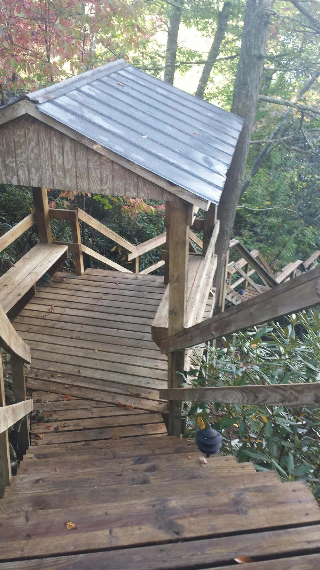 Metal roofed shelter over wooden steps on a wooded walkway — Skylight Repair & Installation work by our crew in Norwell