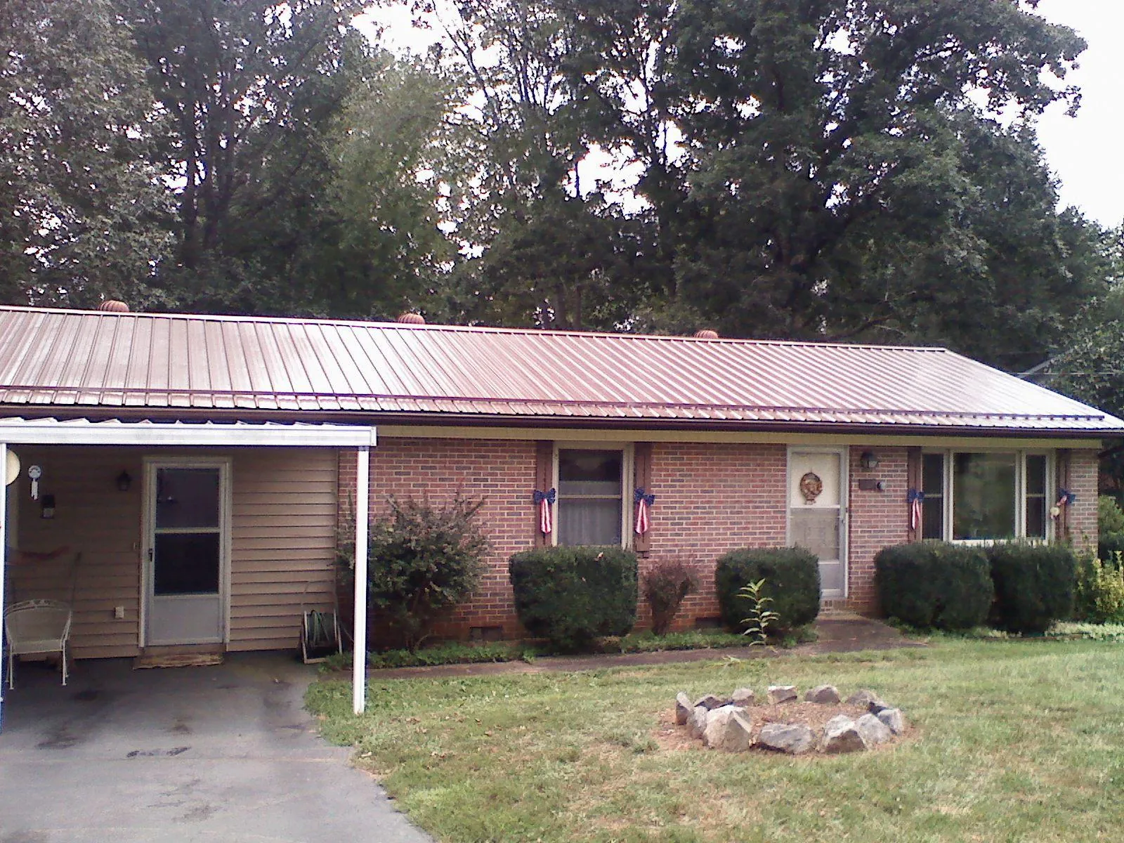 Bronze metal roof and carport on a brick ranch home — Roof Repair work by our crew in Norwell